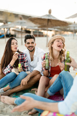 Group of young friends laughing and drinking beer