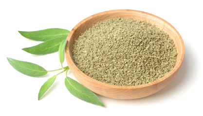 dried sage powder in the wooden plate, isolated on white
