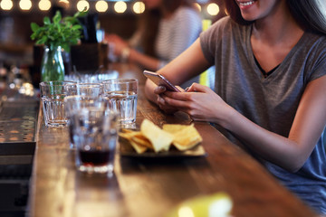 Midsection of woman texting in restaurant
