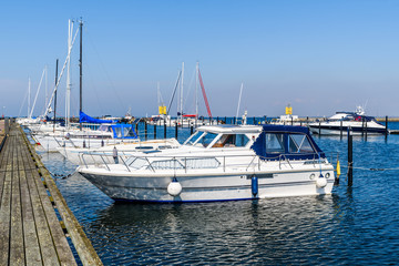 Marina with motorboats and sailboats on a sunny and warm day. Logos and id removed.