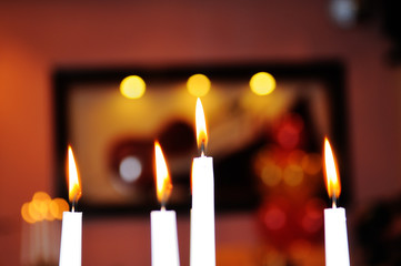 Lighted candles on a dark blurred background.