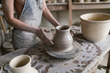 Fototapeta na wymiar potter sculpts a vase on a potter's wheel