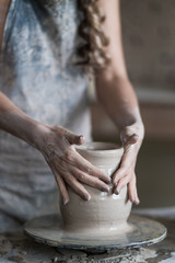 potter sculpts a vase on a potter's wheel