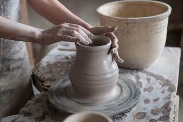 potter sculpts a vase on a potter's wheel