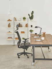modern office room workplace with bookcase and wood table. Laptop tablet and smartphone decoration.