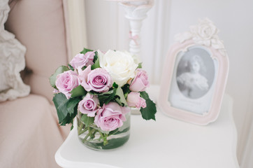 Beautiful roses on a table in a vase, flowers in the room, home cosiness
