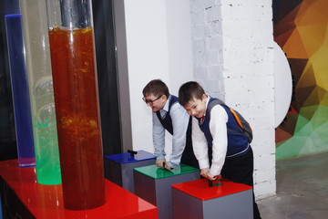 A boy and a girl are studying the exhibits at an interactive scientific and educational exhibition.