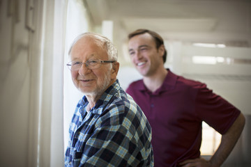 Portrait of a smiling senior man with a supportive male nurse.