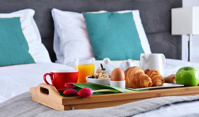 Breakfast on tray in bed in hotel room