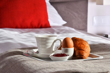 Breakfast on tray in bed in hotel room