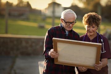Mature nurse and senior man admiring a piece of art.