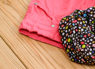Children's or women's clothes on wooden background.