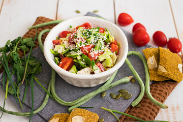 Fresh vegetables Greek salad with tomatoes, cucumbers, onion slices and sprouts. Served with olive oil. Raw vegan vegetarian healthy food