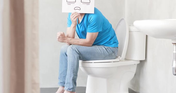 man with constipation on toilet