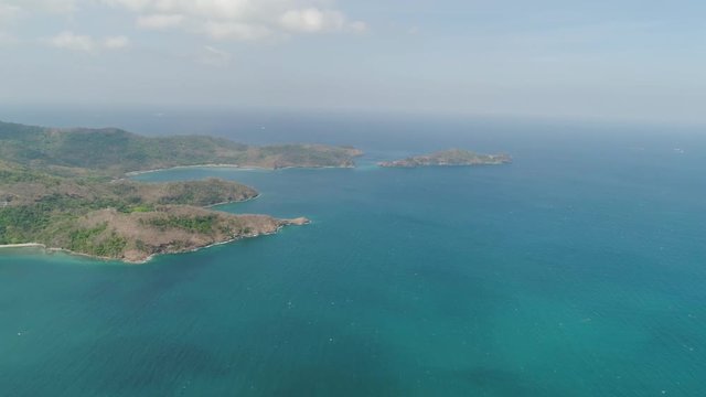 Aerial view of coast with beaches, island Limbones, lagoons and coral reefs. Neela cove, Philippines, Luzon. Coast ocean with turquoise water. Tropical landscape in Asia.