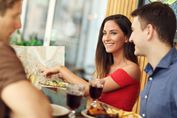 Group Of Tourists Looking On Map In Restaurant