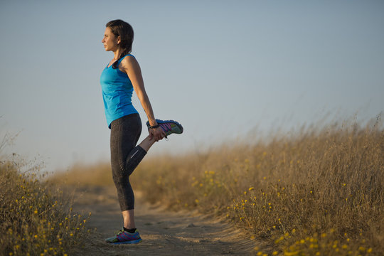 Mid Adult Woman Doing Warm Up Stretches Before Exercising.