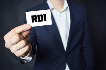 Businessman shows business card with the inscription:ROI