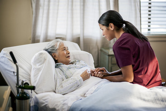 Nurse talking and consoling senior patient in hospital