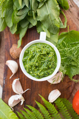 Avocado spinach green spread, dip Mix sauce with spoon. With basil leaves, ready for lunch or dinner with backed potato and vegetables salad. raw vegan vegetarian healthy food.