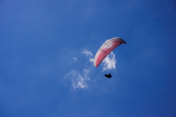 Paraglider fly against blue sky background with clouds
