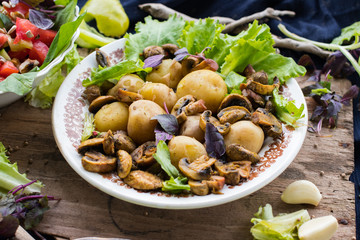 Backed potatoes and roasted mushrooms on salad leaves. Organic farm lunch or dinner. Raw vegan vegetarian healthy food