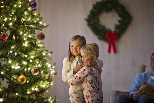 Two young girls hugging on Christmas day.