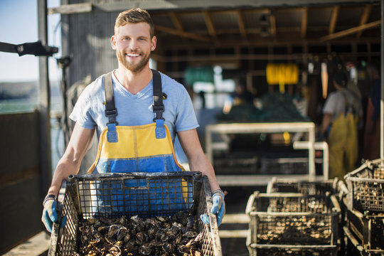 Young man shows caught shellfish.