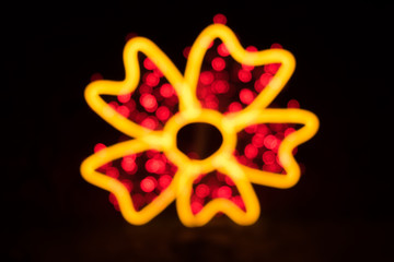 Colorful blurred bokeh of light in flower shape isolated on black background