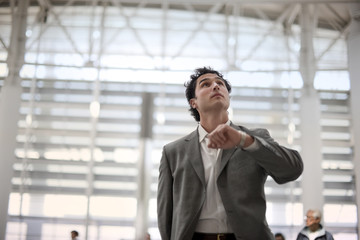 Businessman checking times on an airport information sign.