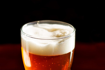Beer in a glass in the bar is on the table close up