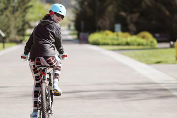 Young woman riding bicycle on path.