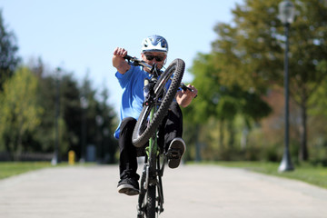 Man doing a wheelie on a bicycle.
