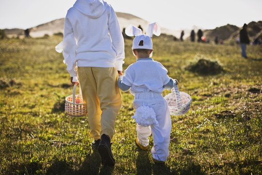 Two brothers in Easter costumes on an Easter egg hunt