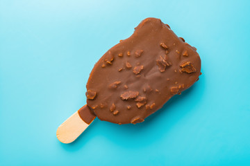 chocolate outer ice cream starts melting on a blue background