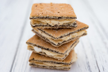 square shape sandwich biscuits a white wood background