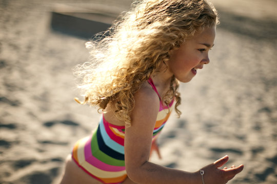 Young girl running along the beach.