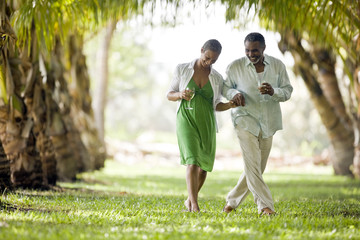 Couple hand in hand with wine glasses.