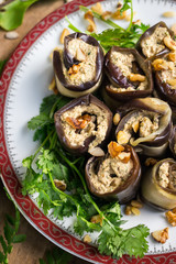 Fototapeta na wymiar Roasted eggplant rolls with walnuts, garlic, coriander, oil, onion. Traditional Georgian food cold snack. Rolls for dinner or lunch. Raw vegan vegetarian healthy food