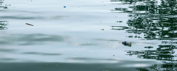 Plastic drum floating on a beach side and other flowing plastic garbage