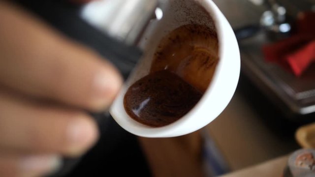 Pour hot milk into a cappuccino cup in slow motion.