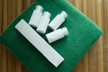 Hotel cosmetics kit on green towel