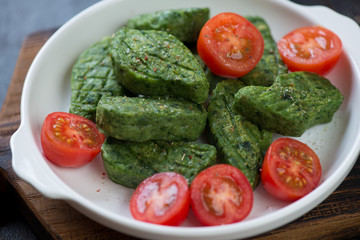 White plate with fried vegetable nuggets and cherry tomatoes, selective focus, closeup