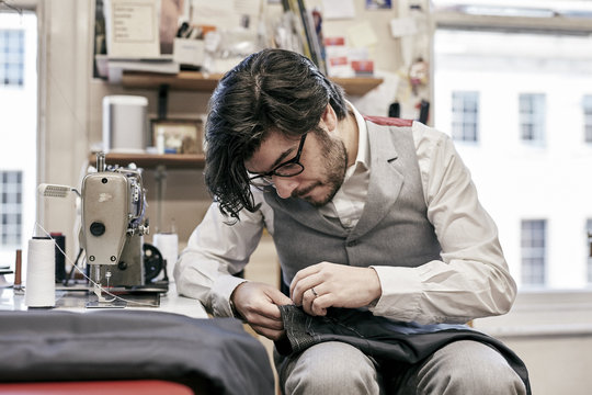 Man sewing suit by hand in family tailor business