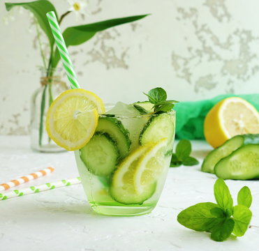 Glassware with refreshing lemon, cucumber and mint fruits cocktail, detox water on white  background