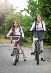 Fototapeta premium Two girls commuting to school on bicycles