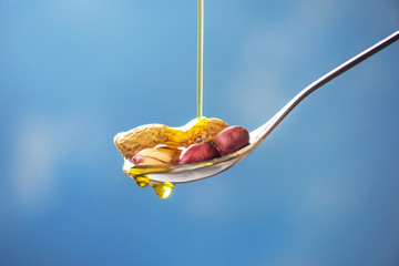 Natural peanut oil with spoon and nuts