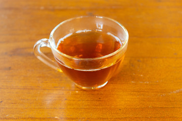 Hot tea with lemon in a glass box with a casual brew. Rest from work