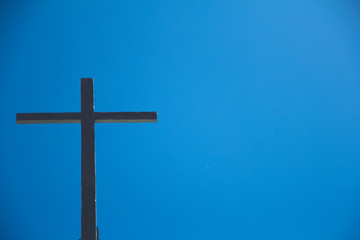 The Old wooden cross with the blue sky background.