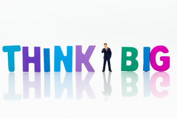 Miniature people: Businessman with text THINK BIG. Image use for idea,, business concept.